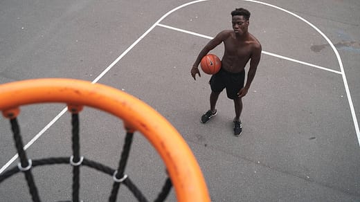 man standing near basketball hoop holding a basketbal