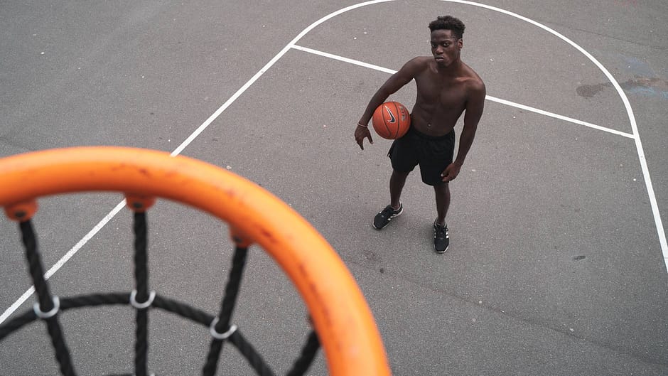 man standing near basketball hoop holding a basketbal