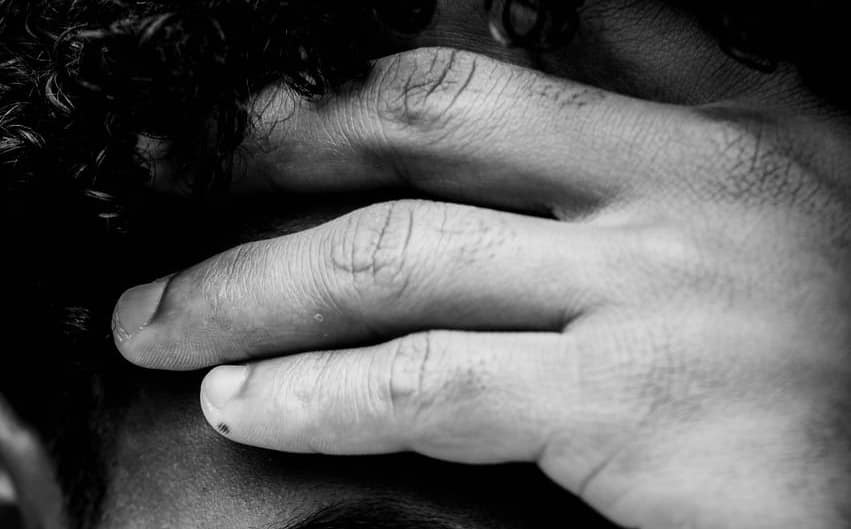 man holding his face